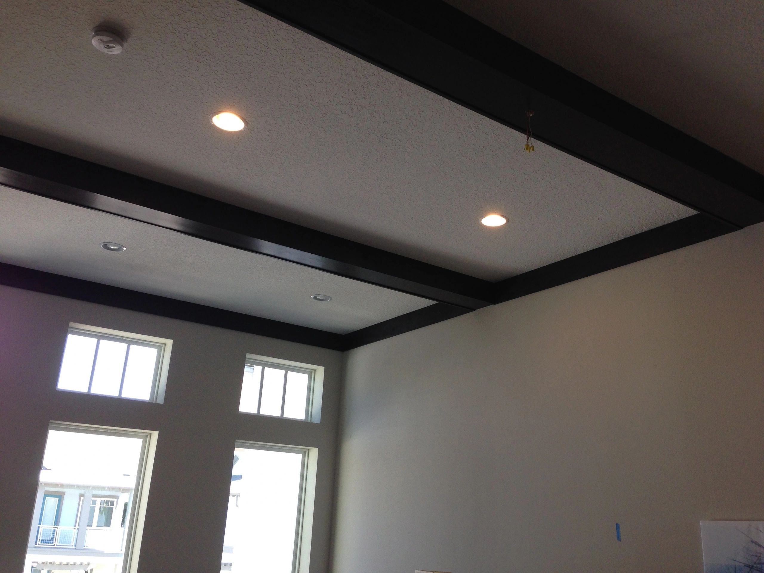 Coffered ceiling with recessed lighting and black trim beams